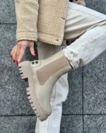 Elegant beige ankle boots with a chunky sole, ideal for casual and modern outfits.