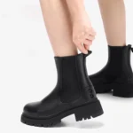 Stylish black leather ankle boots with a chunky sole, perfect for casual and trendy outfits.